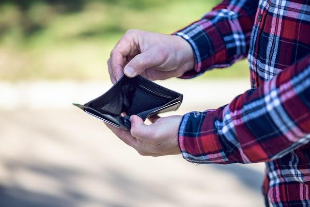 An individual holding an empty wallet