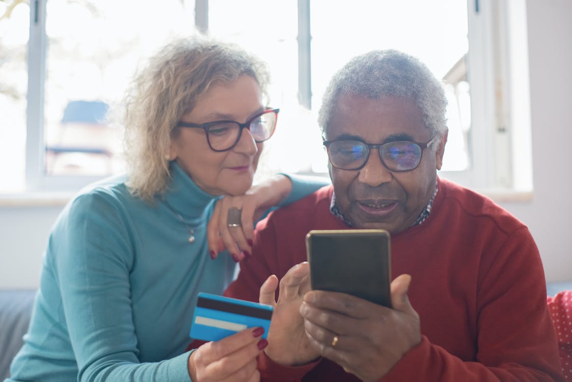 an elderly couple using a credit card.