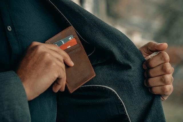 An individual putting multiple credit cards in his pocket