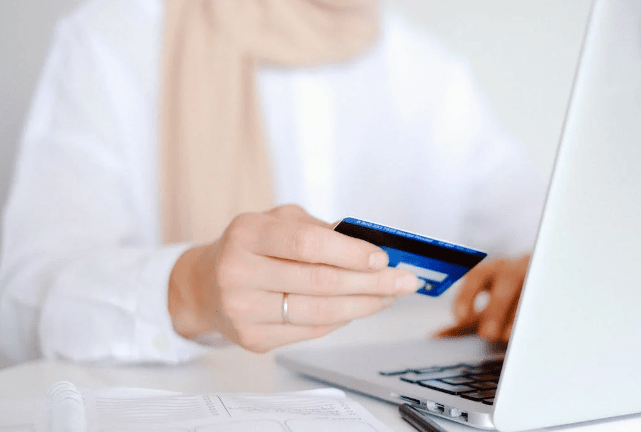 Woman using a credit card for online purchase. 