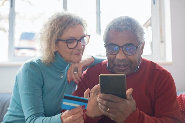 An elderly couple setting up spending alerts