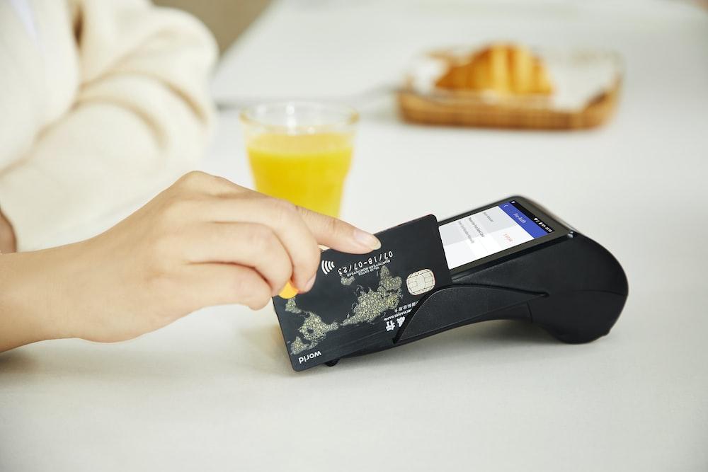 A person using their credit card at a cafe