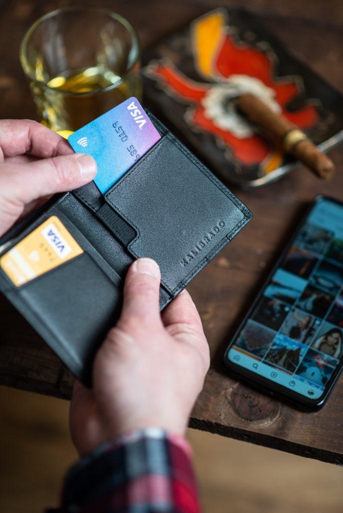A person taking out their credit card from a wallet