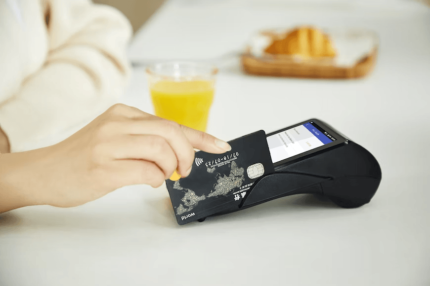 A person sliding their travel credit card on a machine