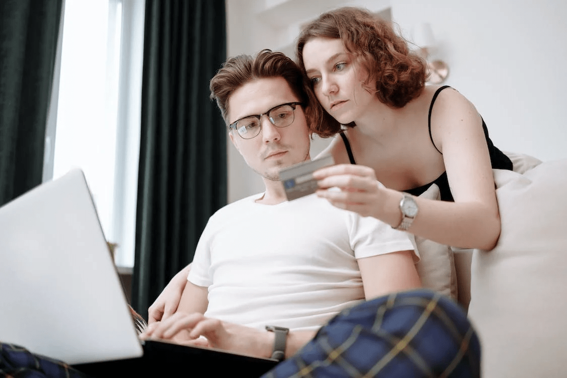 Two people typing their credit card information on a shopping website