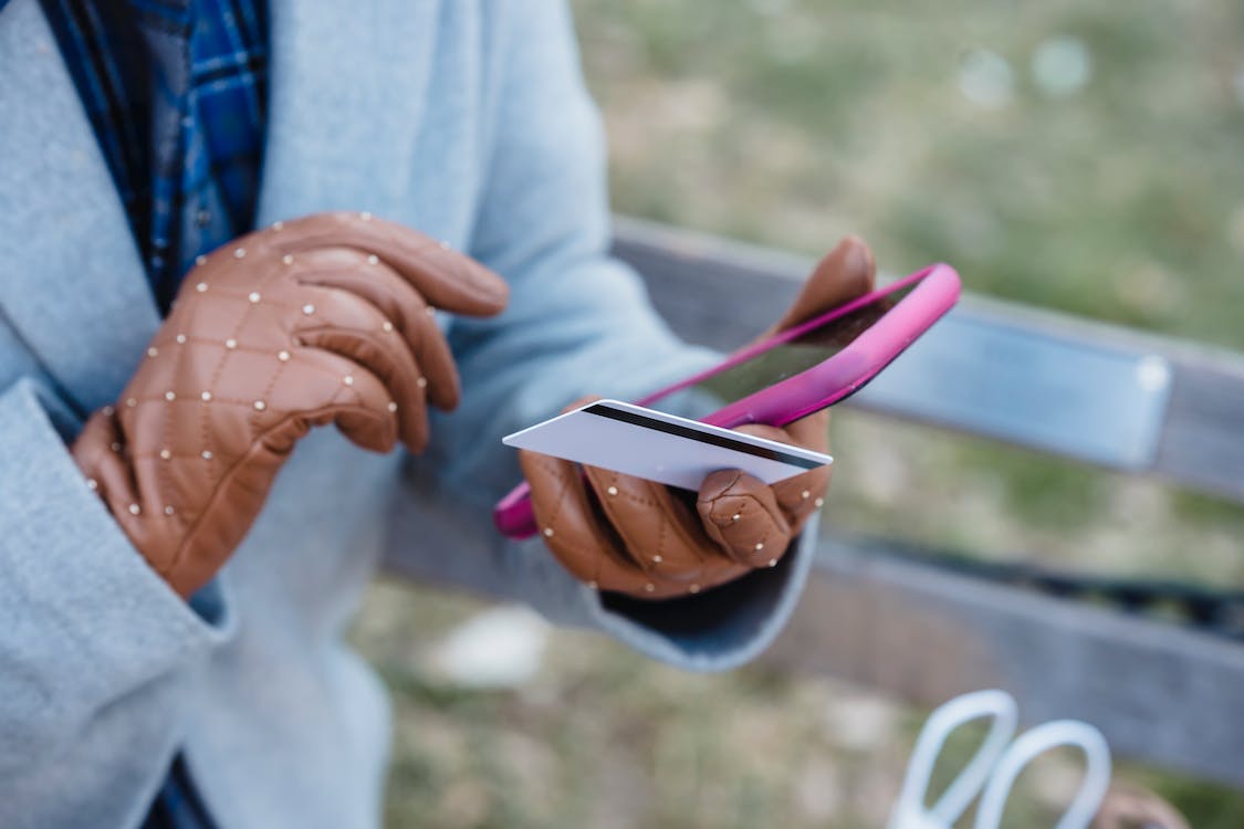 Woman with online payment via smartphone in park