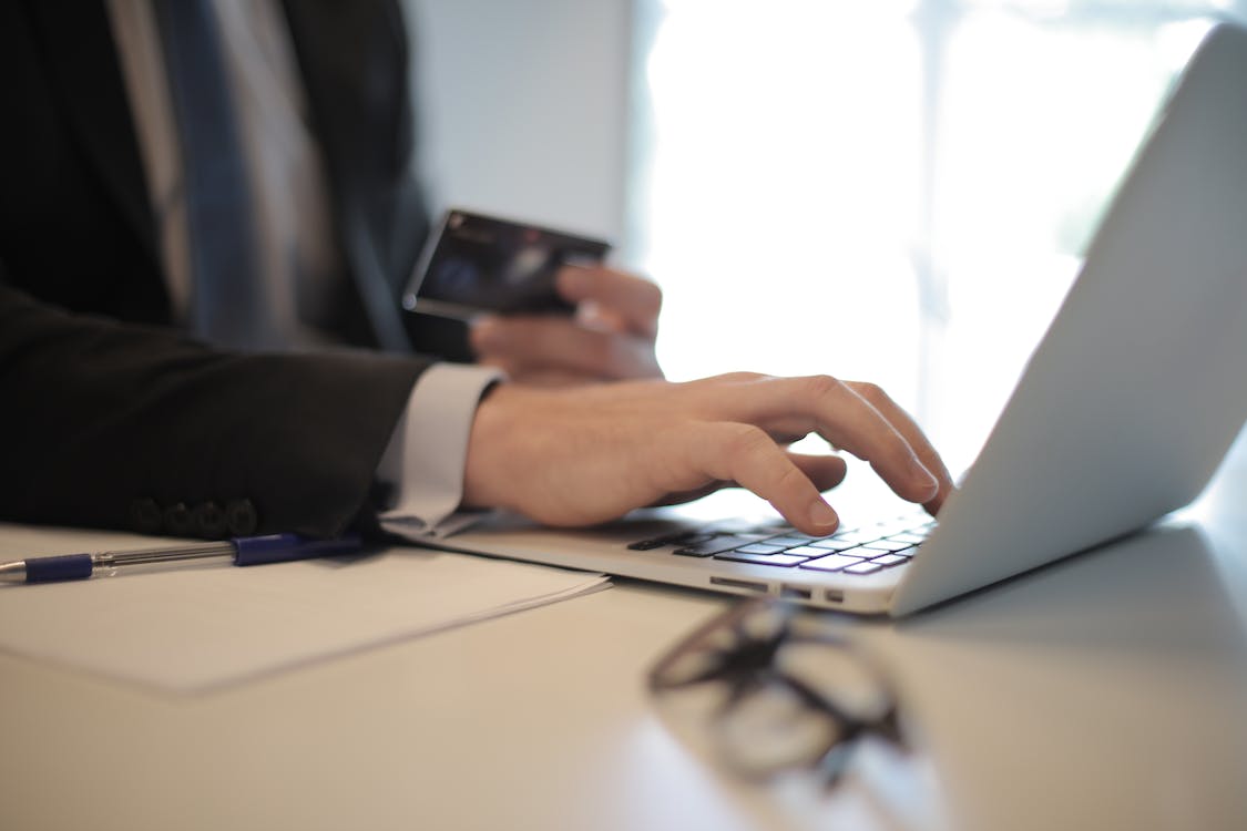 person in a black suit holding a credit card