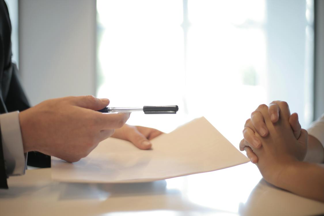 a person giving a Business Credit document and pen