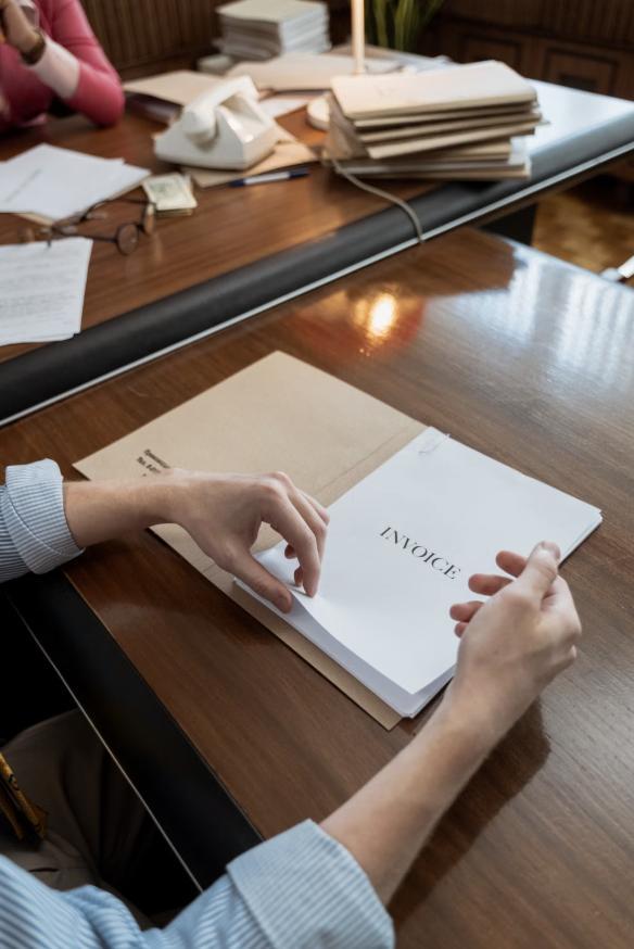 neatly arranged invoices inside a file on a wooden table
